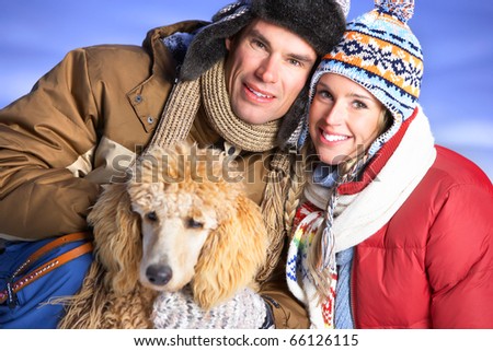 Young  happy smiling couple with dog. Winter
