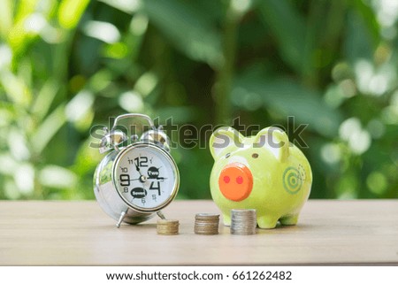 Coin, piggy Bank and clock on wooden,Saving money concept