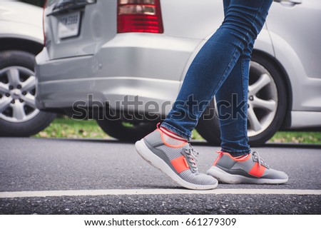 Girl walking on road, low angle and rear view.