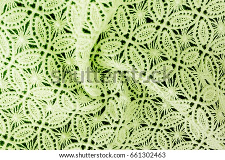 Image texture background, decorative lace with pattern.  green vintage lace background. Green lace on white spandex background, macro view. Ornamental round lace