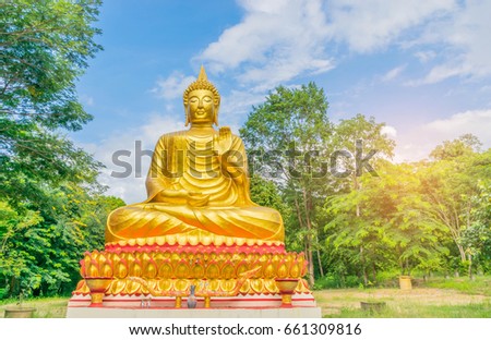 The soft focus of big Buddha with  beautiful sky and cloud in Thailand,by the beam light and lens flare effect tone.This is public domain made from donation money from people in the village.