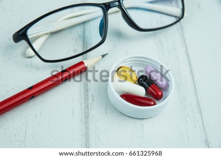 drugs in a cap with pencil and glasses 