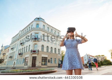 Young Woman in summer dress with VR glasses outdoor.