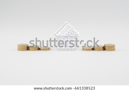 Paperwork as house place between step pile of gold coins as work is going to be successful with white background. Business and finance concept photography.