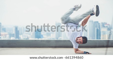 Bboy doing some stunts - Street artist breakdancing outdoors Royalty-Free Stock Photo #661394860