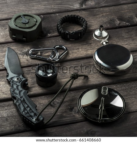 hiking travel gear on wood backdrop. Flat lay of outdoor travel equipment items for mountain camping trip.
