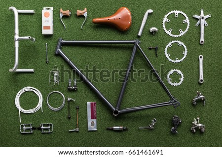 Vintage bicycle frame and parts laid out on a green mat ready for assembly Royalty-Free Stock Photo #661461691