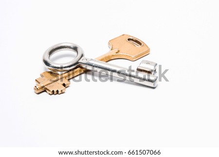 Two keys of yellow and white color lying cross on a cross on a white background