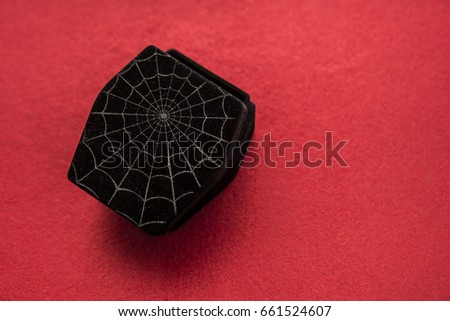 open cover of black coffin with spiderweb on red bloody background. empty copy space for inscription or other objects. halloween party. holiday background. spider web