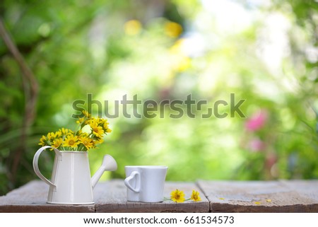 Notebook with yellow flower and cup on wooden table