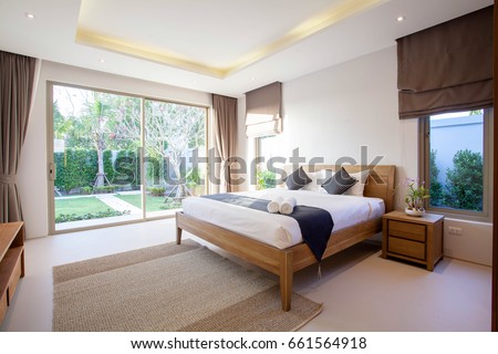 real Luxury Interior design in bedroom of pool villa with cozy king bed with high raised ceiling  home, house ,building Royalty-Free Stock Photo #661564918