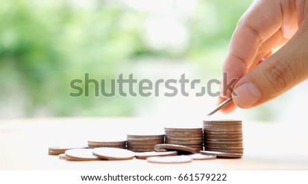Close up of female hand stacking coins 