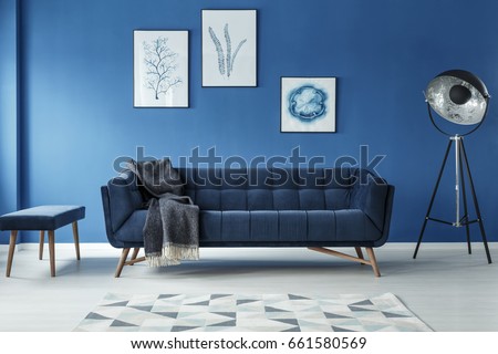 Elegant sofa, vintage lamp and footstool in stylish room