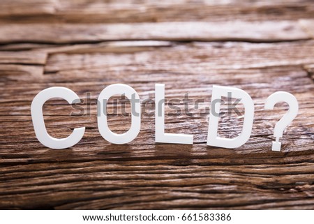 Close-up Of A Cold Text With Question Mark Sign On Wooden Background