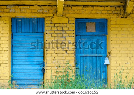 Closed blue wooden doors on yellow brick wall background