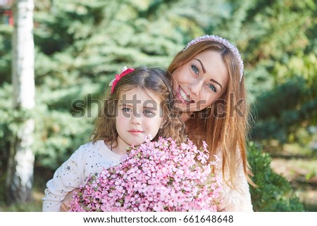 Happy family. Young beautiful  mother and her daughter having fun With bouquet of flowers. Positive human emotions, feelings, joy.