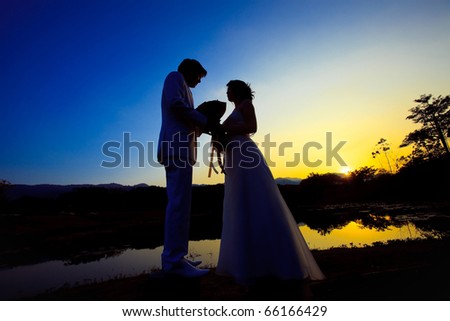 romantic silhouette picture of bride and groom after sunset