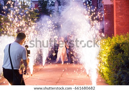 Wedding Videographer Camera Operator is Shooting Bridal Event in the Fireworks Royalty-Free Stock Photo #661680682
