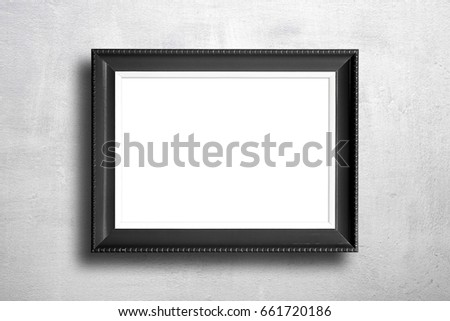 Black blank picture frame on cement wall.
