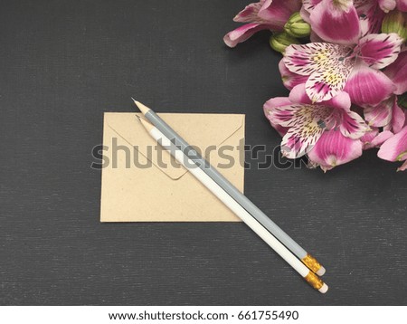 craft envelope with alstroemerias on black background with space for your text  