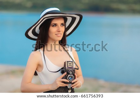 Summer Tourist Girl with Retro Camera and Big Straw Hat - Tourist woman with Vintage accessories capturing holiday memories
