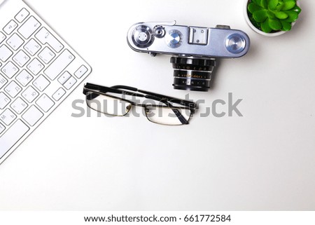 Computer keyboard, cactus and camera lie on table