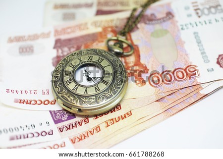 Money and clock on a chain on a white background. Time is money.