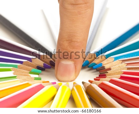 closeup of crayons and one finger on white background