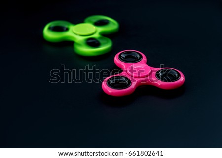 Pink and green spinner on a dark background. spinners