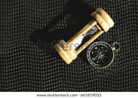Compass and clock sand on floor black with sunlight shine