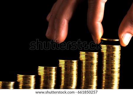 Hand putting money coins stack in finance and banking concept.