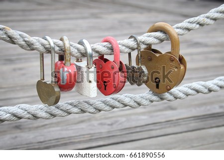 lot of different love padlocks on thick hemp rope. the inscription on the lock "advice and love". not brand Royalty-Free Stock Photo #661890556
