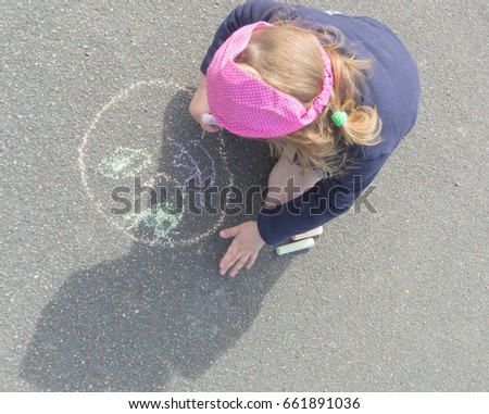 on the pavement in chalk draws a person's baby girl.