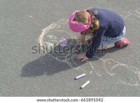 a Sunny day on the pavement in chalk and draws a mother a baby girl.