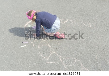summer day on asphalt with chalk draws a mother a baby girl.