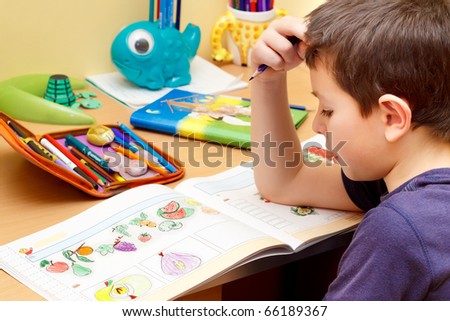 boy doing homework  with color pencil, painting fruits Royalty-Free Stock Photo #66189367