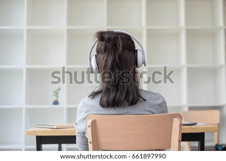 Happy young student girl using headphone