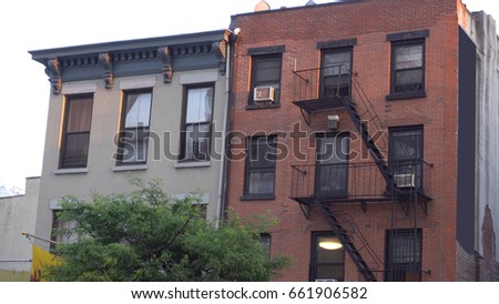 Typical Brooklyn New York City style apartment building exterior establishing shot outside fire escape facade. photo day time DX evening sunset time