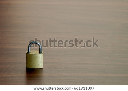 The small key lock on the wooden table background