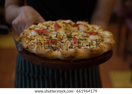 Young woman holding plate with tasty pizza, close up view  / soft focus picture 