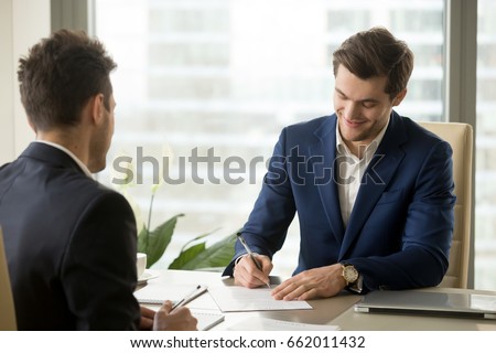 Smiling businessman signing paper at meeting, satisfied entrepreneur concludes contract, holder verifies agreement by putting authorized handwritten signature, entrepreneur making profitable deal Royalty-Free Stock Photo #662011432