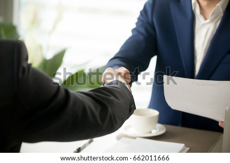 Handshake close up, male hands shaking after signing contract, businessmen making deal, accepting business offer, forming partnership, successful negotiations result, mutual agreement, help, support Royalty-Free Stock Photo #662011666
