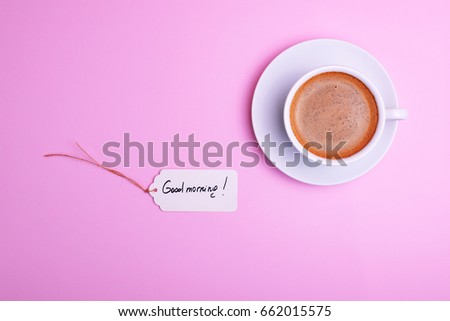 cup of coffee and a saucer and a paper tag with an inscription good morning, a top view