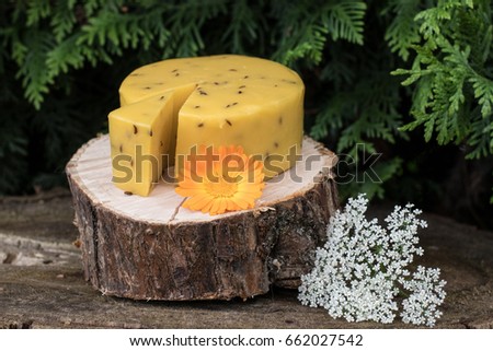 Caraway cheese decorated with flowers on wooden background. Traditional Latvian snack. Celebrating Lego fest in June Royalty-Free Stock Photo #662027542