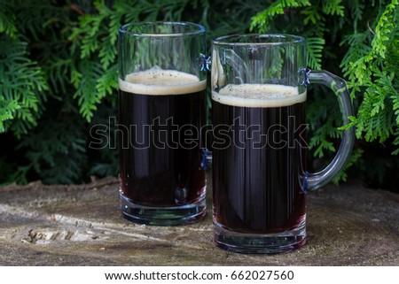 Two glasses of dark beer on wooden background. Midsummer in Latvia. Celebration of traditional Ligo feast in June Royalty-Free Stock Photo #662027560