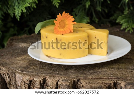 Caraway cheese decorated with flowers on wooden background. Traditional Latvian snack. Celebrating Lego fest in June Royalty-Free Stock Photo #662027572