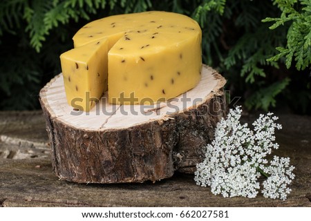 Caraway cheese decorated with flowers on wooden background. Traditional Latvian snack. Celebrating Lego fest in June Royalty-Free Stock Photo #662027581