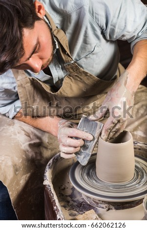 pottery, workshop, ceramics art concept - yong male sculpt some new utensils with hands, tool, fingers and water, man works with potter's wheel and raw fireclay, Mexican, Hispanic, Latino