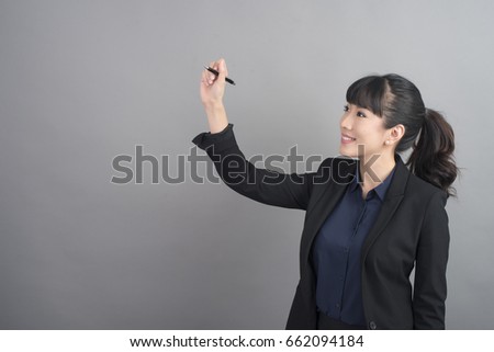 Beautiful Business Woman writing something on grey background