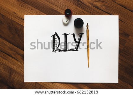 Calligraphy word and tools. Equipment and DIY abbreviation made with ink top view. Painter workshop, small business inspiration, creativity, calligraphy concept.